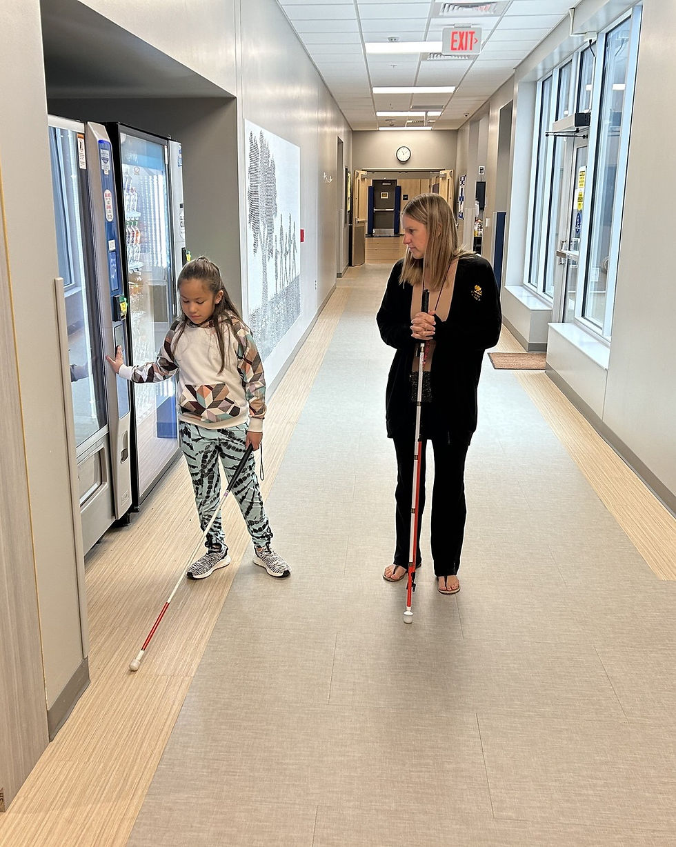 A young girl feeling the vending machine in the hallway during an O&M lesson with her teacher
