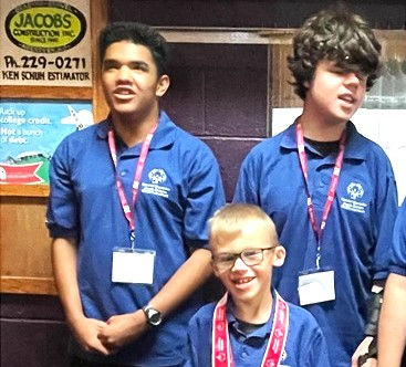 Three males students posing in their SDSBVI Special Olympics shirts during the 2024 state bowling tournament